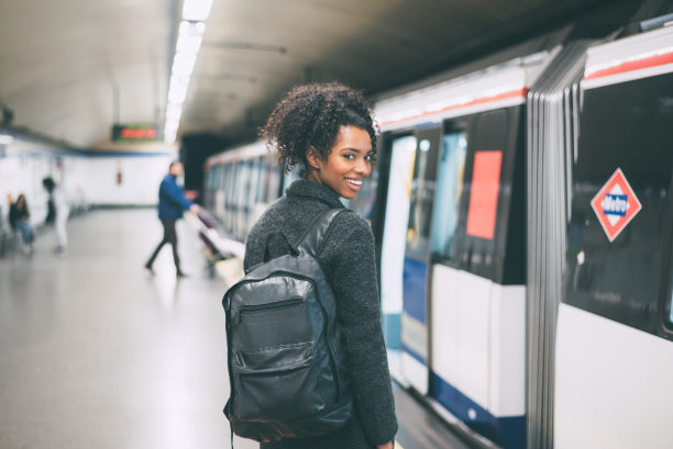 快乐的年轻黑人妇女在地铁站内等待火车素材图片