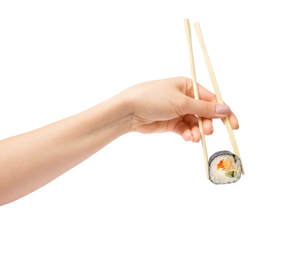 寿司卷与木筷子在女性的手在白色的背景图片下载