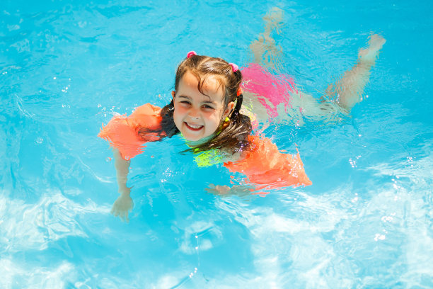 小女孩在水上公园里微笑着在水下游泳图片下载