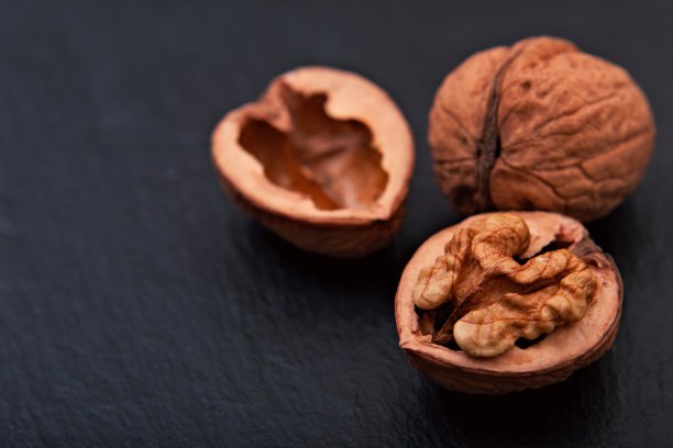 健康食品理念Spot将天然核桃仁放在黑色板岩背景上，复制空间图片下载