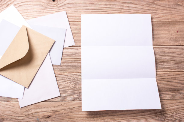 信和信封放在一张木桌上。模拟信格式A4图片下载