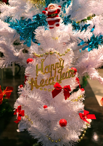 白色圣诞树装饰许多红色的装饰品和可爱的圣诞老人在树顶图片下载