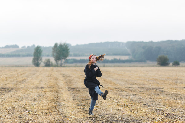 幸福快乐的女人在麦田里玩的图片，美丽的黑发与举起的手享受自由户外，农业生活方式，秋收的概念，秋天的季节图片下载