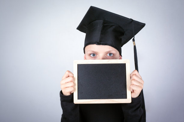 手里拿着黑板的男孩。知识，教育和成功的职业背景图片下载