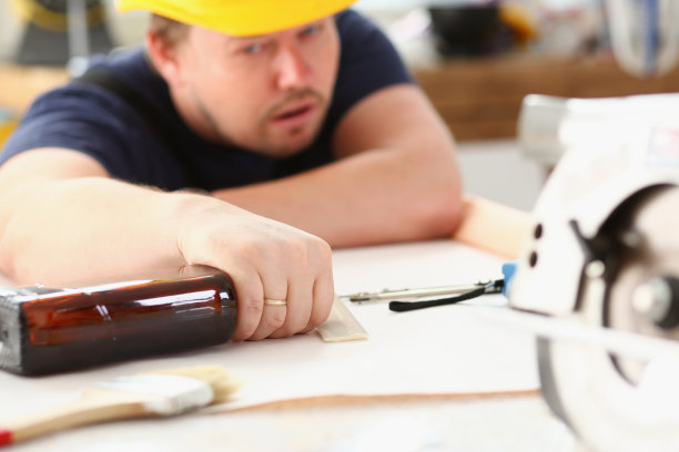 戴着黄色头盔的醉酒工人的手臂图片下载