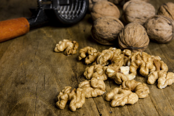 胡桃仁和胡桃夹在旧木板上的静物画图片下载