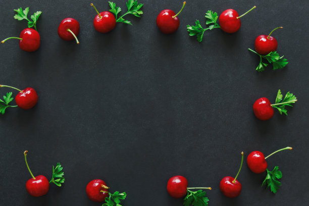 新鲜的樱桃在黑色花岗岩桌上，孤立的背景在俯视图平铺与网页封面或横幅的拷贝空间。樱桃有很高的维生素C和酸甜口味。健康的水果的概念图片下载