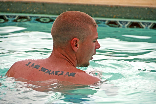 年轻的20岁左右的男子游泳晒黑皮肤纹身在肩膀上图片下载