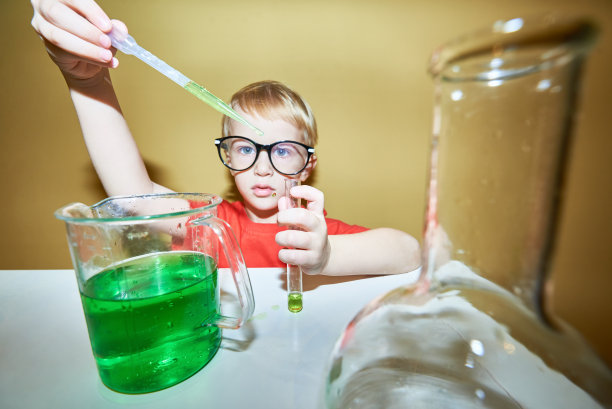 年轻的化学家用移液管向试管中添加试剂图片下载