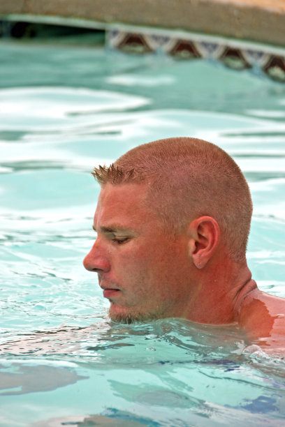 年轻的20多岁的白人男子在游泳池思考严肃的脸图片下载