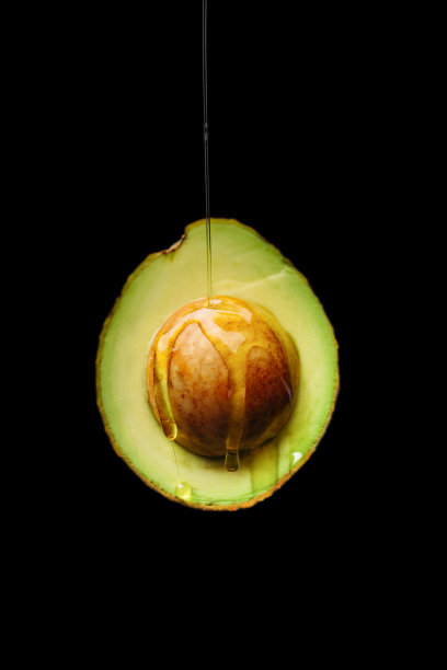 熟鳄梨，在黑色背景上切成两半图片下载