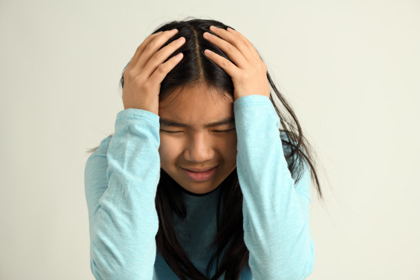 悲伤，沮丧的年轻女孩的头在手中图片下载