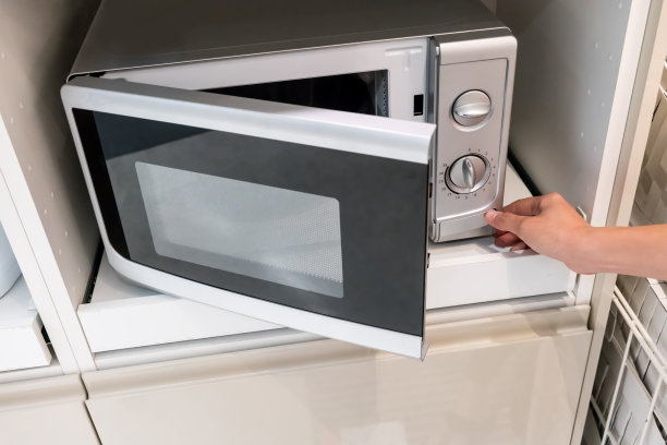 女人的手按按钮打开微波炉门图片下载