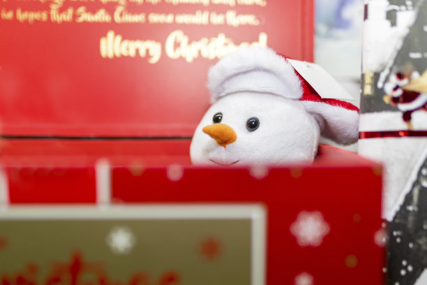 复古节日的毛绒玩具雪人从红色的圣诞礼品盒中探出图片下载