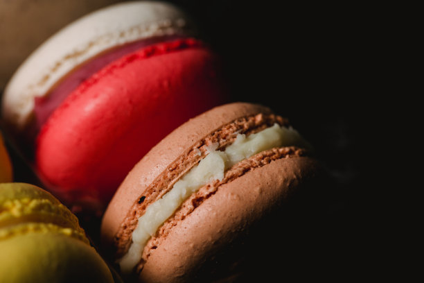 彩色的杏仁饼干设置在黑色的背景。特写镜头食物照片。微距摄影图片下载