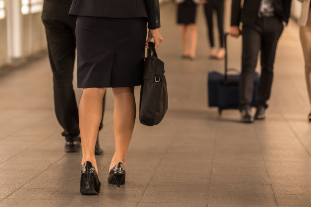 在工作日里，女商人和男商人提着公文包图片下载