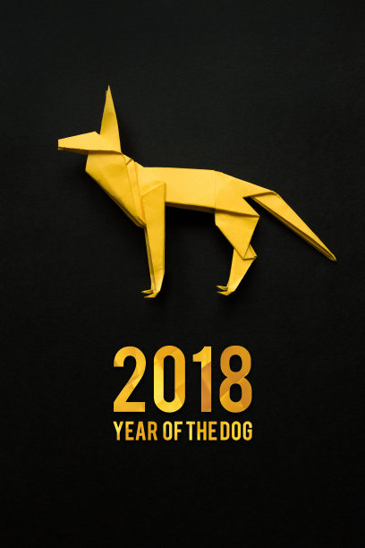 黄色折叠折纸狗在黑色的纸背景。垂直假日明信片，海报，横幅。图片下载