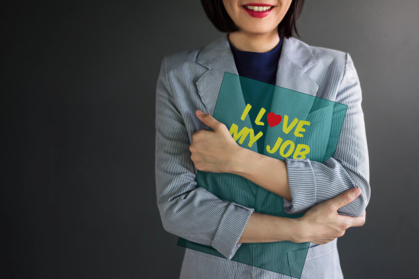 积极的成就理念，职业女性微笑着，拥抱着透明卡片上的“我爱我的工作”图片下载