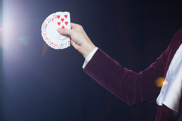 手与卡片特写。魔术师的腹部显示扇形的卡片在黑色的背景。魔术师，变戏法的人，有趣的人，黑魔法，幻觉图片下载
