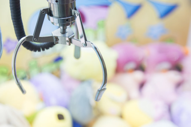 爪游戏或橱柜抓娃娃。自动贩卖机中随机选择毛绒玩具的机械臂图片下载