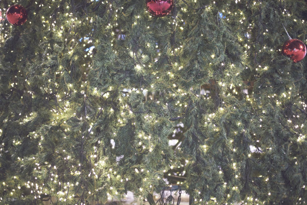 背景与发光的灯和圣诞球在圣诞树上图片下载