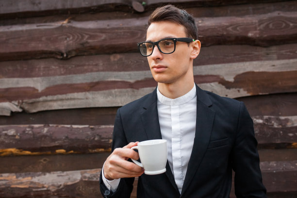 英俊的男人，拿着一个白色的杯子，孤立在白色的背景上图片下载