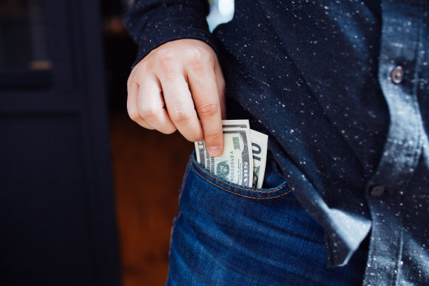 人的手正在把钱放进口袋图片下载