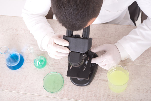 一个科学家通过显微镜观察的高角度照片图片下载