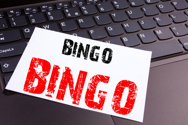 在办公室里用笔记本电脑键盘写宾果游戏。经营理念为“刻字赌博赢价格成功工作坊”在黑色背景与复制空间图片下载