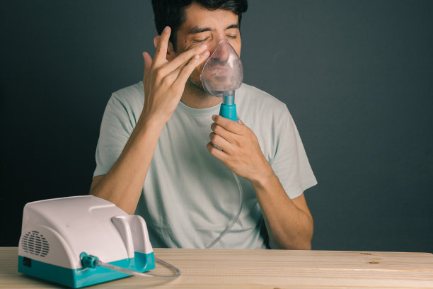 患有鼻窦炎的男人使用家用吸入器/雾化器素材图片
