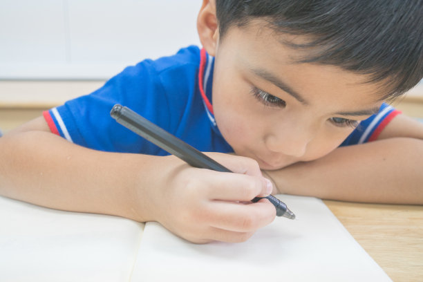 小孩正在桌子上写字图片下载