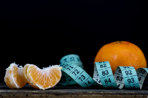 美味的普通话在旧的深色木制餐桌上。裁缝的尺寸包裹着一个官子。黑色背景图片下载