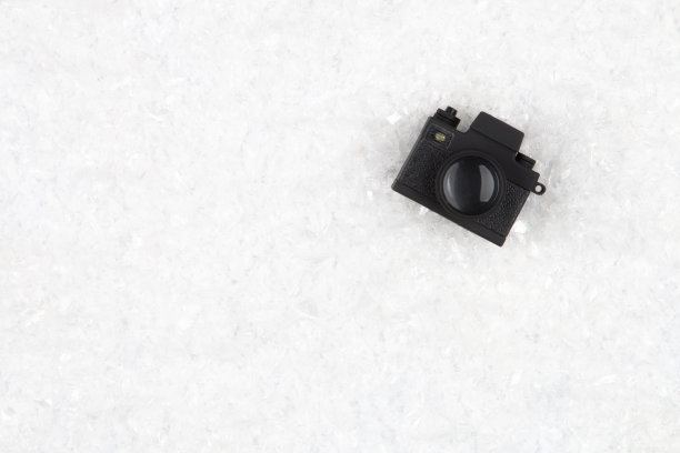 黑色的照片相机在白色的雪地背景与复制空间。俯视图图片下载