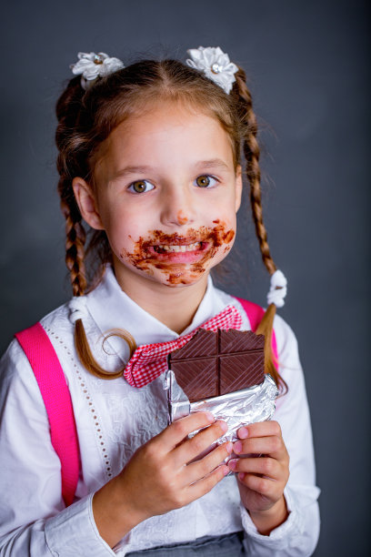 一个可爱的小女孩正在吃巧克力图片下载