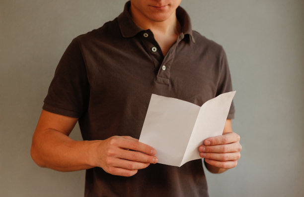 男人阅读空白的白色传单小册子。传单。小册子握手。铜版纸显示清晰。表模板。图片下载