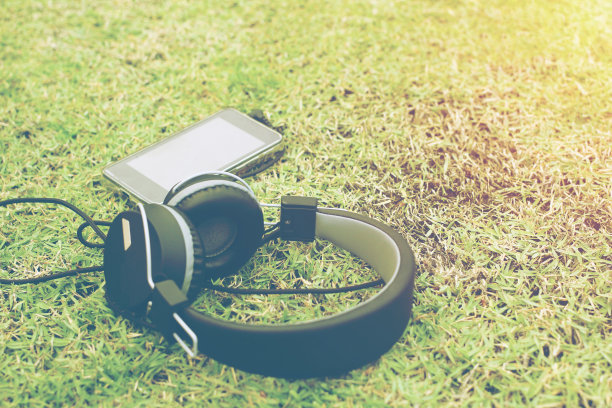 草地上放着耳机和手机。图片下载