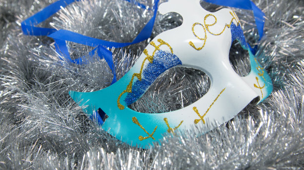 狂欢节的面具躺在银箔上。图片下载