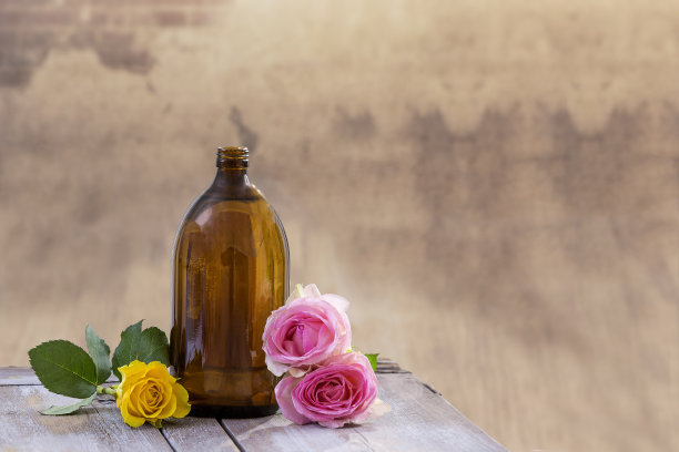水疗和健康的概念:准备与粉色玫瑰精油，棕色瓶酊剂木板，公寓背景图片下载