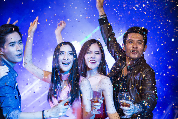 一群年轻的亚洲女人在夜猫子一起跳舞。微笑着跳舞的女人。有观的人。图片下载