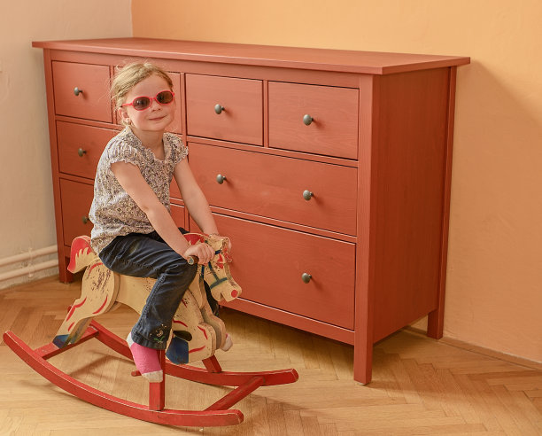 小女孩骑着木马。小女孩戴着红色的眼镜。图片下载