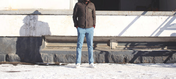 在城市的冬日里，穿着夹克和牛仔裤的时尚男士图片下载