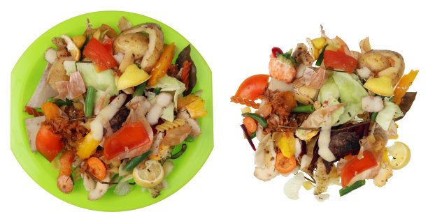 素餐在白色的餐桌和绿色的塑料盘子上烹饪后留下的食物垃圾。图片下载