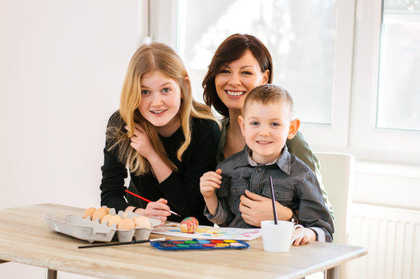 一位母亲和她的孩子们在画复活节彩蛋。图片下载