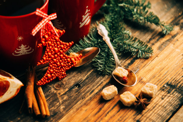 美丽的圣诞餐桌设置图片，闪亮的白色盘子与红色杯子为咖啡装饰的节日晚餐，树枝莓和圣诞老人星在节日餐具，新年晚会，平安夜图片下载