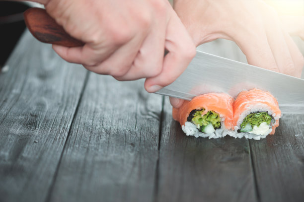 手里拿着刀切着木板上的特写镜头图片下载