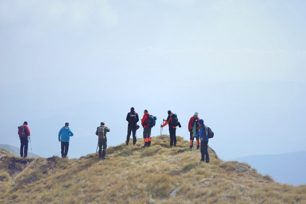 一群背着背包走在山路上的游客图片下载