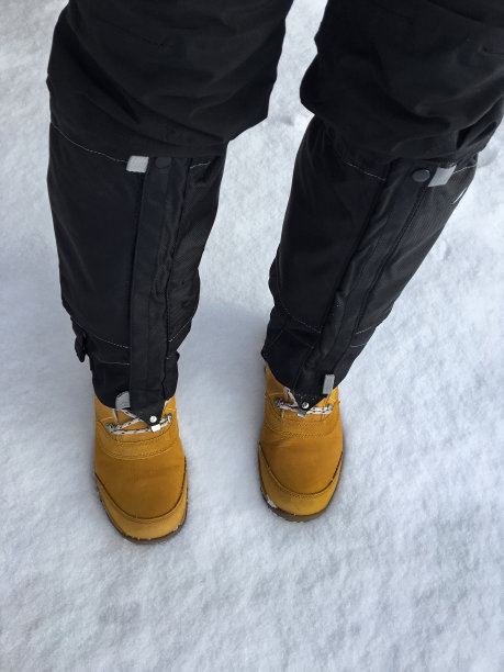 黑色防水雪罩，黑色滑雪裤，棕色户外鞋图片下载