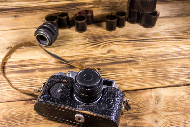 带胶卷和镜头的复古相机放在木桌上图片下载