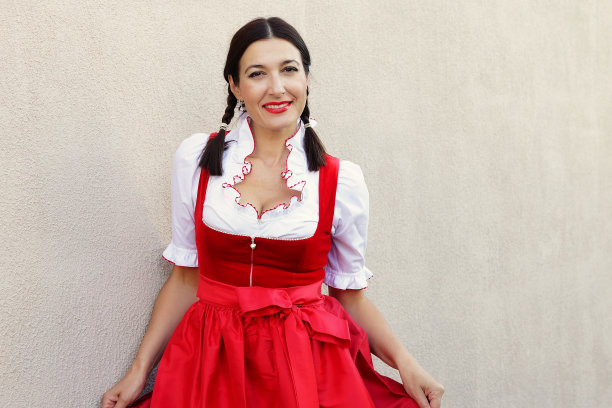 十月节的概念。德国巴伐利亚妇女，穿着典型的紧身连衣裙，手持啤酒杯图片下载