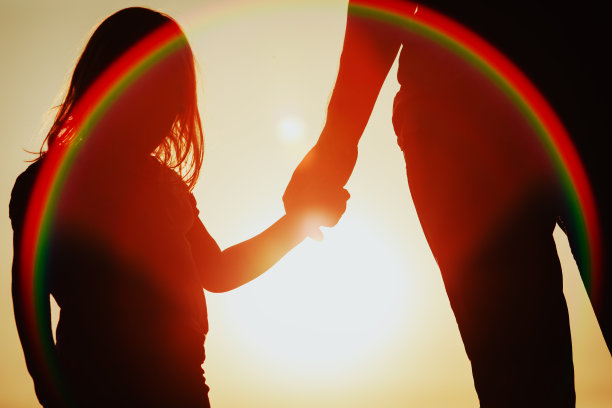 日落时分，小女孩牵着父母的手的剪影图片下载